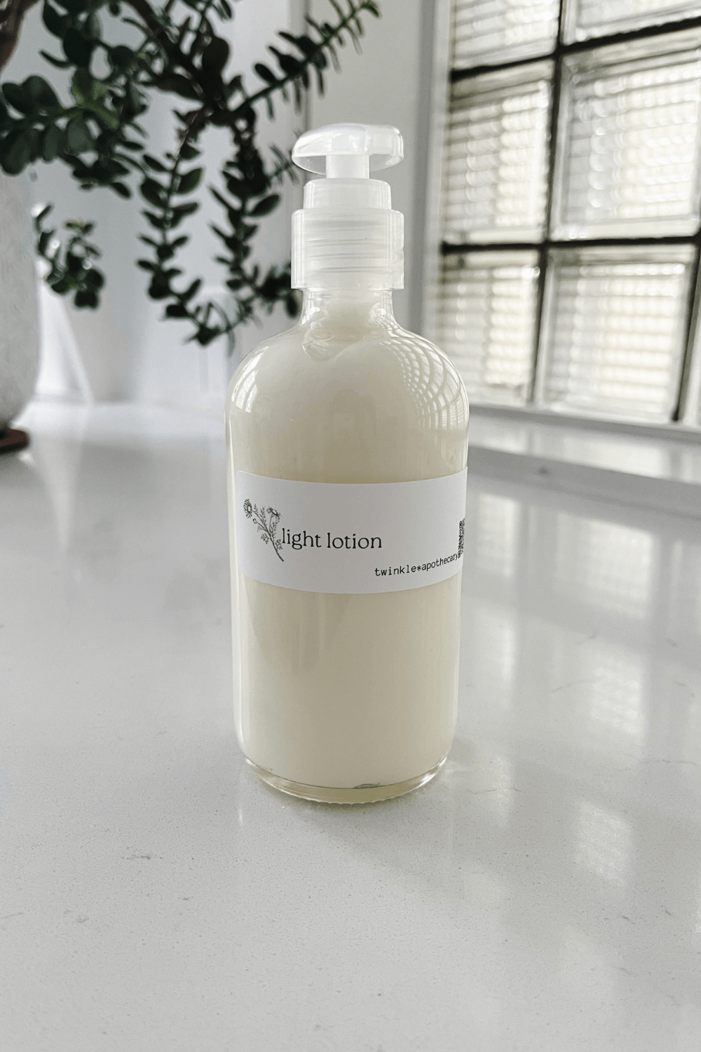 8 oz glass bottle of twinkle apothecary light lotion 
